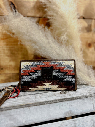 Woven wallet with geometric pattern on a wooden surface