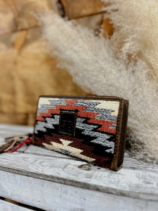 Woven clutch with geometric pattern on a wooden surface