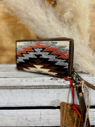 Woven wallet with geometric pattern on a wooden surface
