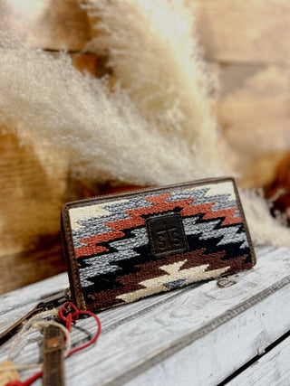 Woven wallet with geometric pattern on a wooden surface
