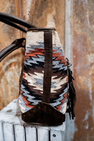 Woven bag with geometric pattern on a wooden surface