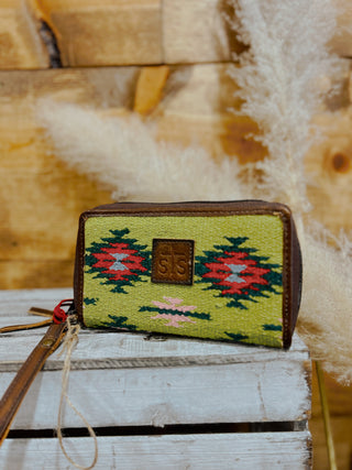 Small green pouch with patterned design on a wooden surface