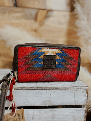 Woven wallet with geometric pattern on a wooden surface