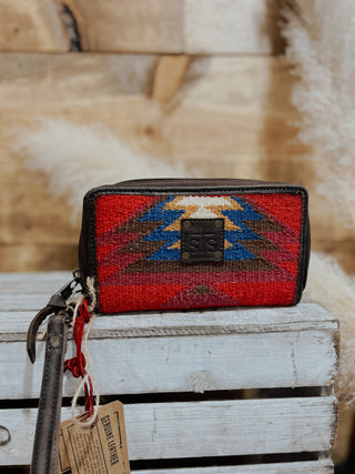 Woven wallet with geometric pattern on a wooden surface