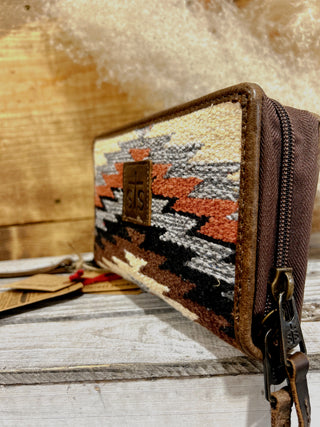 Woven patterned pouch with a zipper on a wooden surface