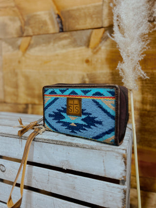 Blue patterned pouch with brown accents on a wooden surface