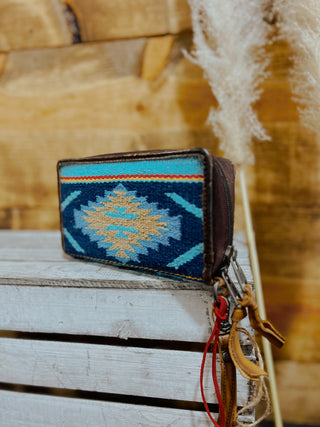 Small wallet with blue and gold pattern on a wooden surface