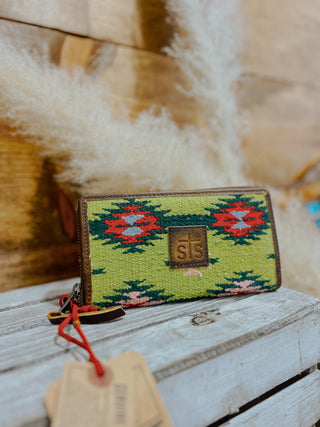 Green patterned wallet with a brand logo on a wooden surface