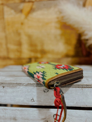 Embroidered pouch with floral design on a wooden surface