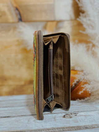 Brown leather wallet with floral pattern on a textured surface