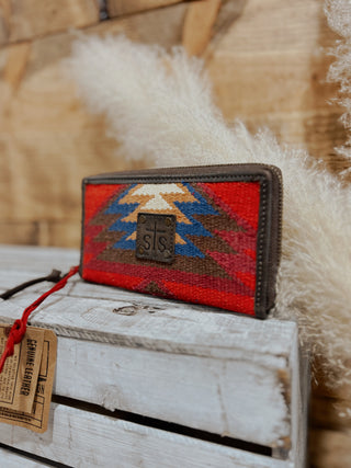 Woven wallet with geometric pattern on a wooden surface