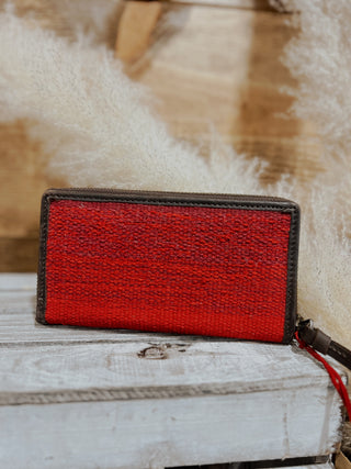 Red woven wallet on a wooden surface with a textured background