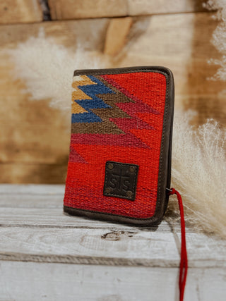 Red woven wallet with geometric pattern on a wooden surface