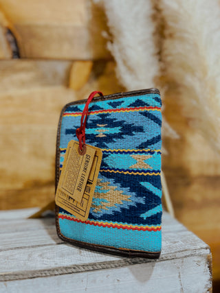 Blue patterned wallet with a tag on a wooden surface