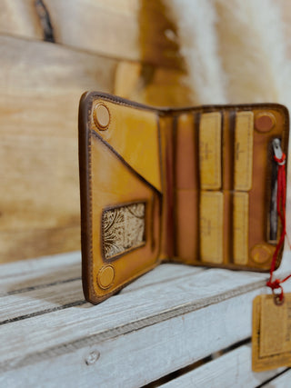 Brown leather wallet with visible stitching on a wooden surface