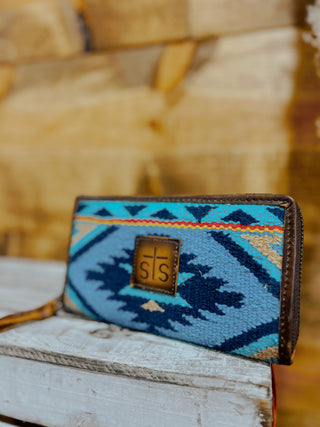 Blue patterned wallet with a brand logo on a wooden surface