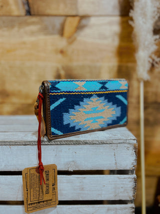 Wristlet with blue and gold pattern on a wooden surface