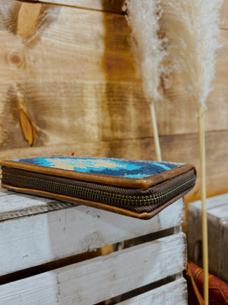 Small woven pouch with a colorful pattern on a wooden surface