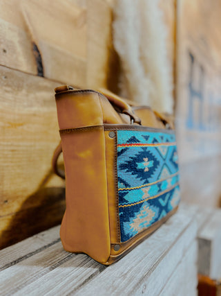 Handbag with blue geometric pattern on a wooden surface