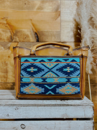 Handbag with blue and brown pattern on a wooden surface