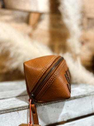 Brown leather pouch with a zipper on a wooden surface