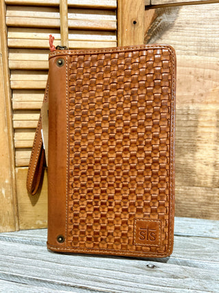 Brown woven leather wallet on a wooden surface
