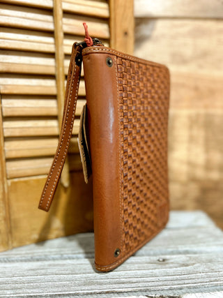 Brown woven leather wallet on a wooden surface with a blurred background