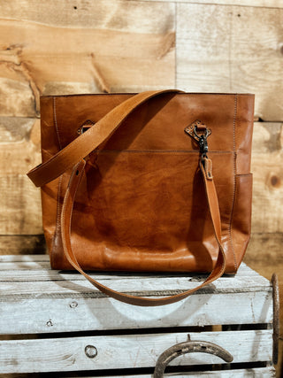 Brown leather bag on a wooden surface with a rustic background