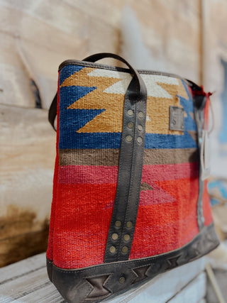 Colorful patterned bag with geometric design on a wooden surface