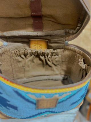 Close-up of a brown bag with a blue patterned strap.