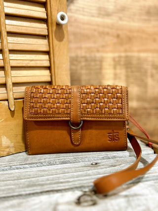Brown woven leather wallet with strap on a wooden surface