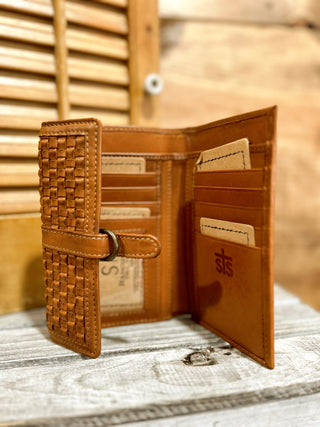 Brown leather wallet with woven pattern on a wooden surface