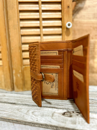 Brown leather wallet with intricate design on a wooden surface