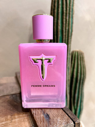 Pink perfume bottle labeled 'Femme Dreams' with a cactus in the background
