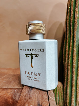 Territorie Lucky perfume bottle on a wooden surface with a cactus in the background