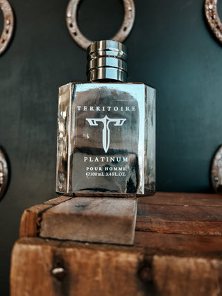 Territoire Platinum pour homme perfume bottle on a wooden surface with a dark background