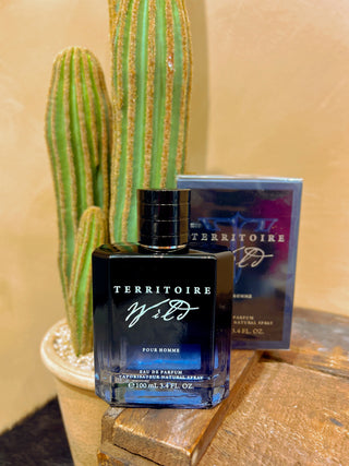 Territoire Wild perfume bottle with packaging on a wooden surface with a cactus in the background