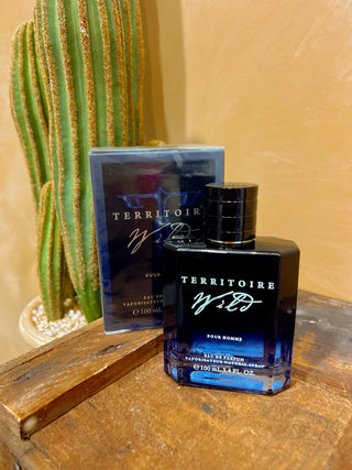 Territoire Wild perfume bottle on a wooden surface with a cactus in the background