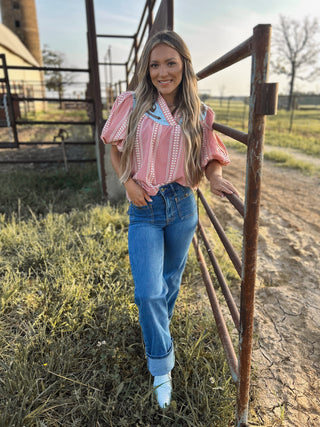Woman standing by a rustic fence in a rural setting
