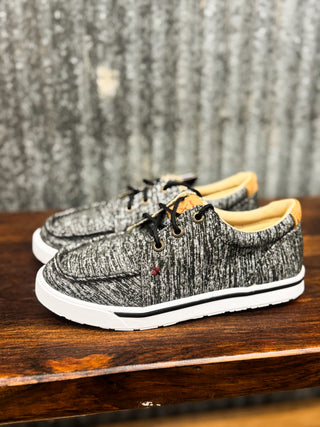 Pair of gray sneakers with white soles on a wooden surface