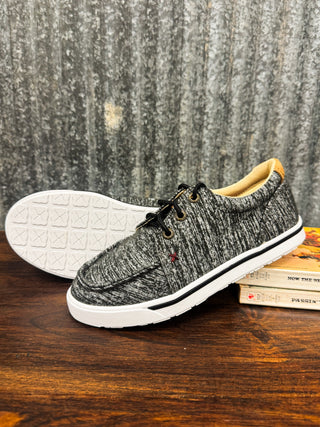 Gray knit shoe with white sole on a wooden surface