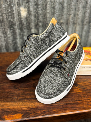 Pair of gray sneakers with white soles on a wooden surface