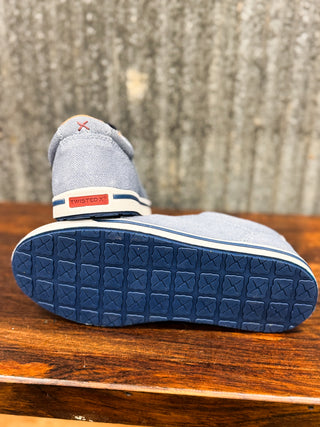 Blue shoe with a textured sole on a wooden surface
