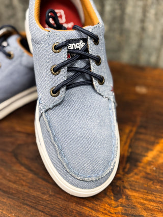 Blue casual shoe with black laces on a wooden surface