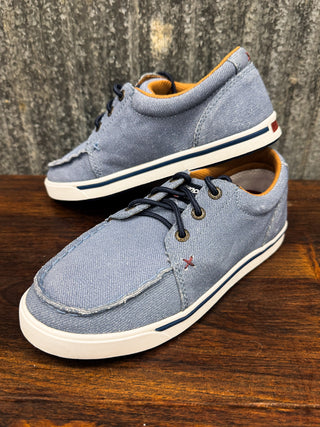 Pair of blue casual shoes on a wooden surface with a textured gray background