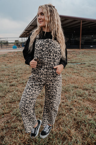 Person wearing a leopard print outfit standing in an open field.