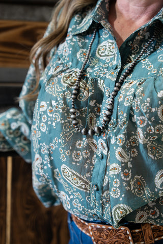 Teal patterned shirt worn by a person with a focus on the upper body.