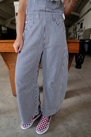 Person wearing a black and white striped outfit with checkered shoes in an indoor setting.