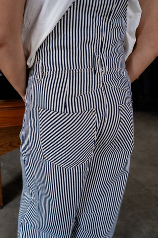 Person wearing a black and white striped apron with a blurred background