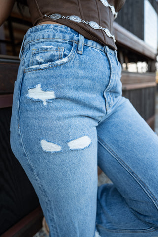 Close-up of distressed blue jeans with a blurred background
